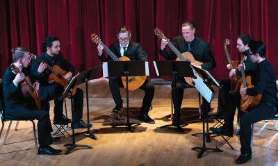 Group of five guitarist performing